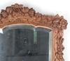 Зеркало в стиле модерн в резной раме с флоральными мотивами.