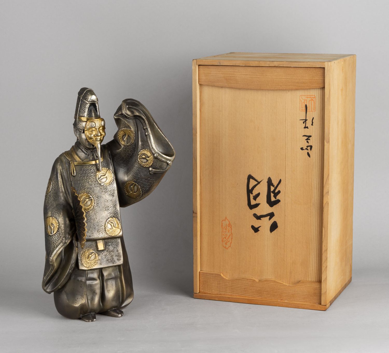 Статуэтка, изображающая персонажа театра Но Окина в праздничном танце. В оригинальной подписной коробке.<br>Япония, Масаюки Кусей, начало XX века.