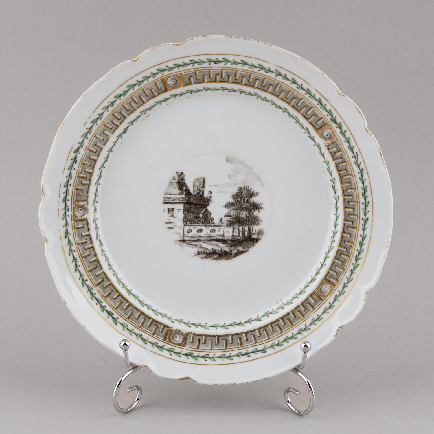 (ИФЗ. Екатерина II) Тарелка из сервиза с пейзажами в медальонах и меандром по борту. 
Россия, Императорский фарфоровый завод, середина 1760-х–1796 годы.