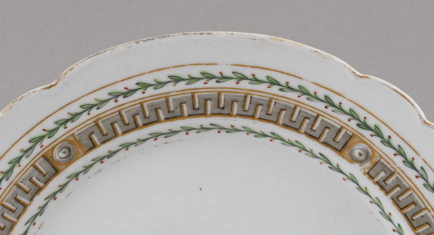 (ИФЗ. Екатерина II) Тарелка из сервиза с пейзажами в медальонах и меандром по борту. 
Россия, Императорский фарфоровый завод, середина 1760-х–1796 годы.