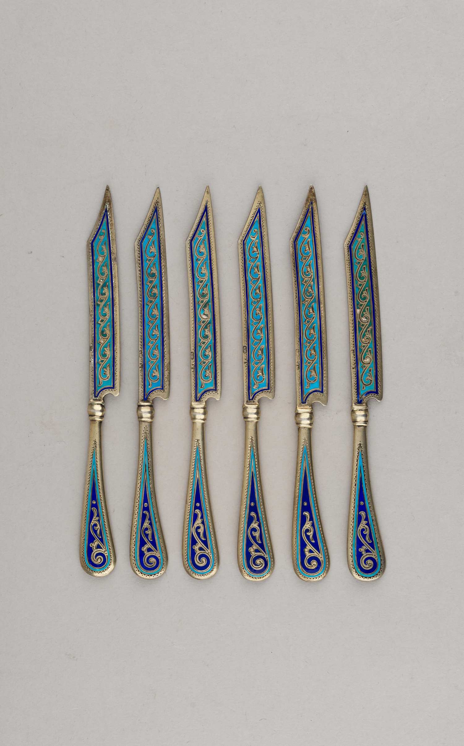 (Антип Кузмичев) Шесть десертных ножей с бирюзовой выемчатой эмалью.
Россия, Москва,  фабрика Кузьмичева Антипа,  1880-е годы.