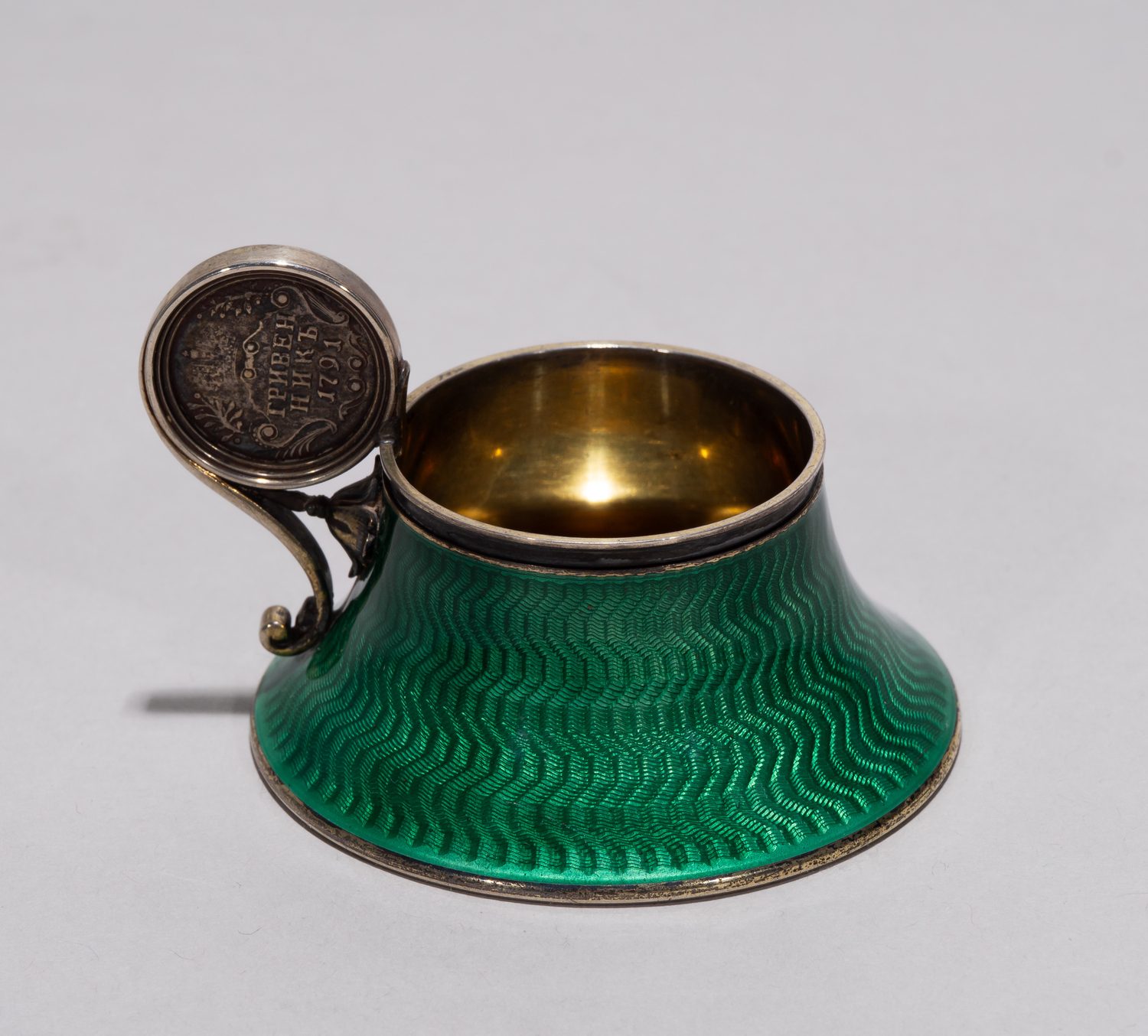 (Фаберже) Чарка изумрудной эмали гильоше с инкрустацией монетой 1791 года. 
Санкт-Петербург, фирма Фаберже, мастер Анна Ринге, начало XX в.