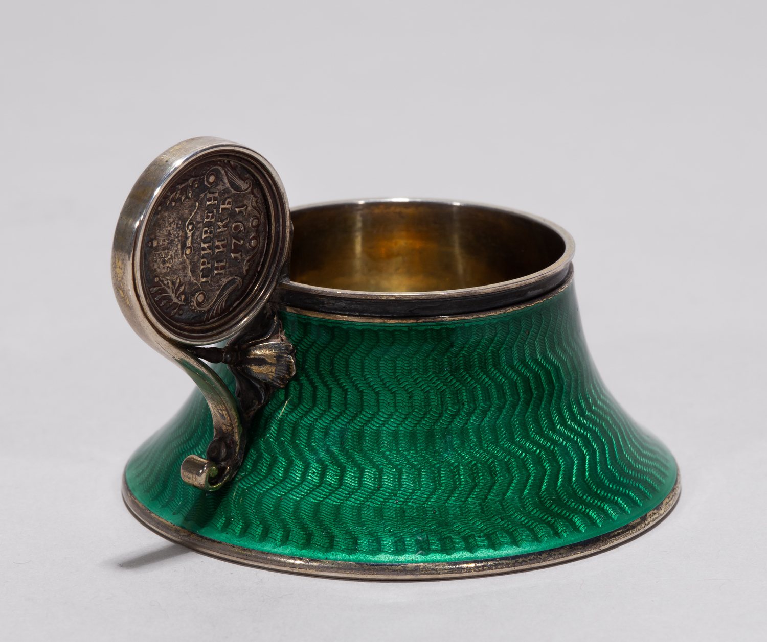 (Фаберже) Чарка изумрудной эмали гильоше с инкрустацией монетой 1791 года. 
Санкт-Петербург, фирма Фаберже, мастер Анна Ринге, начало XX в.