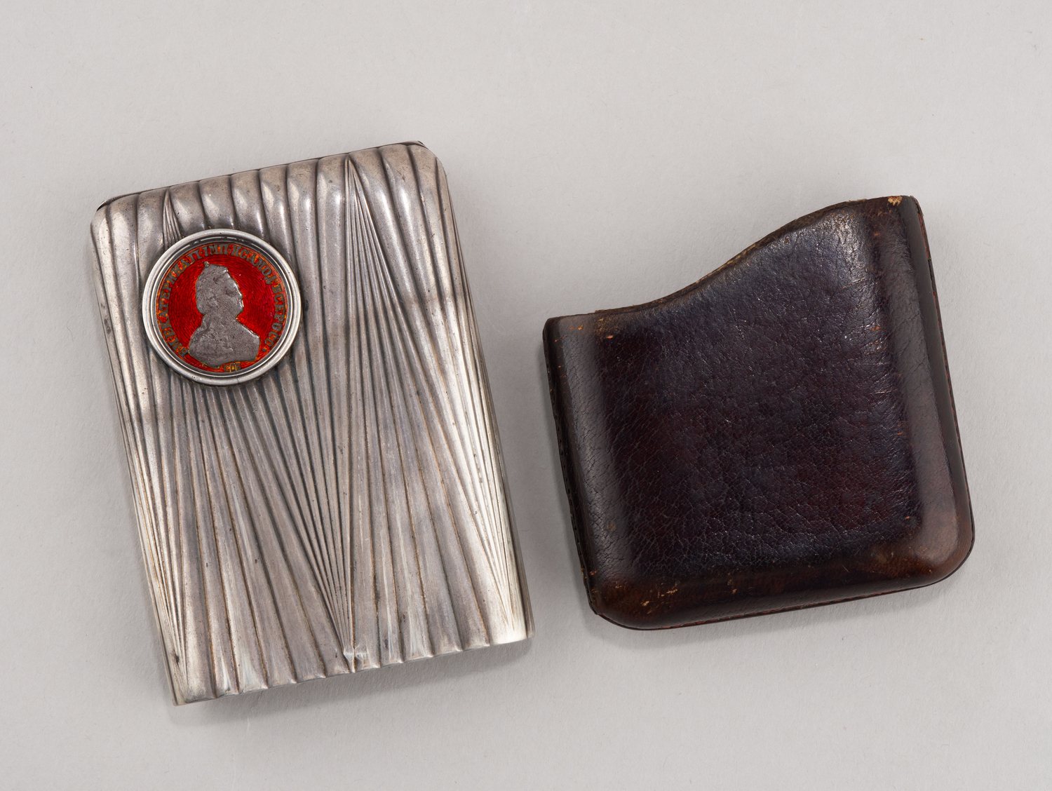 (Фаберже. Андерс Невалайнен). Портсигар с монетой правления Екатерины II в кожаном футляре. Санкт-Петербург, Фирма «Фаберже», мастер Андерс Невалайнен, 1899–1904 гг.
