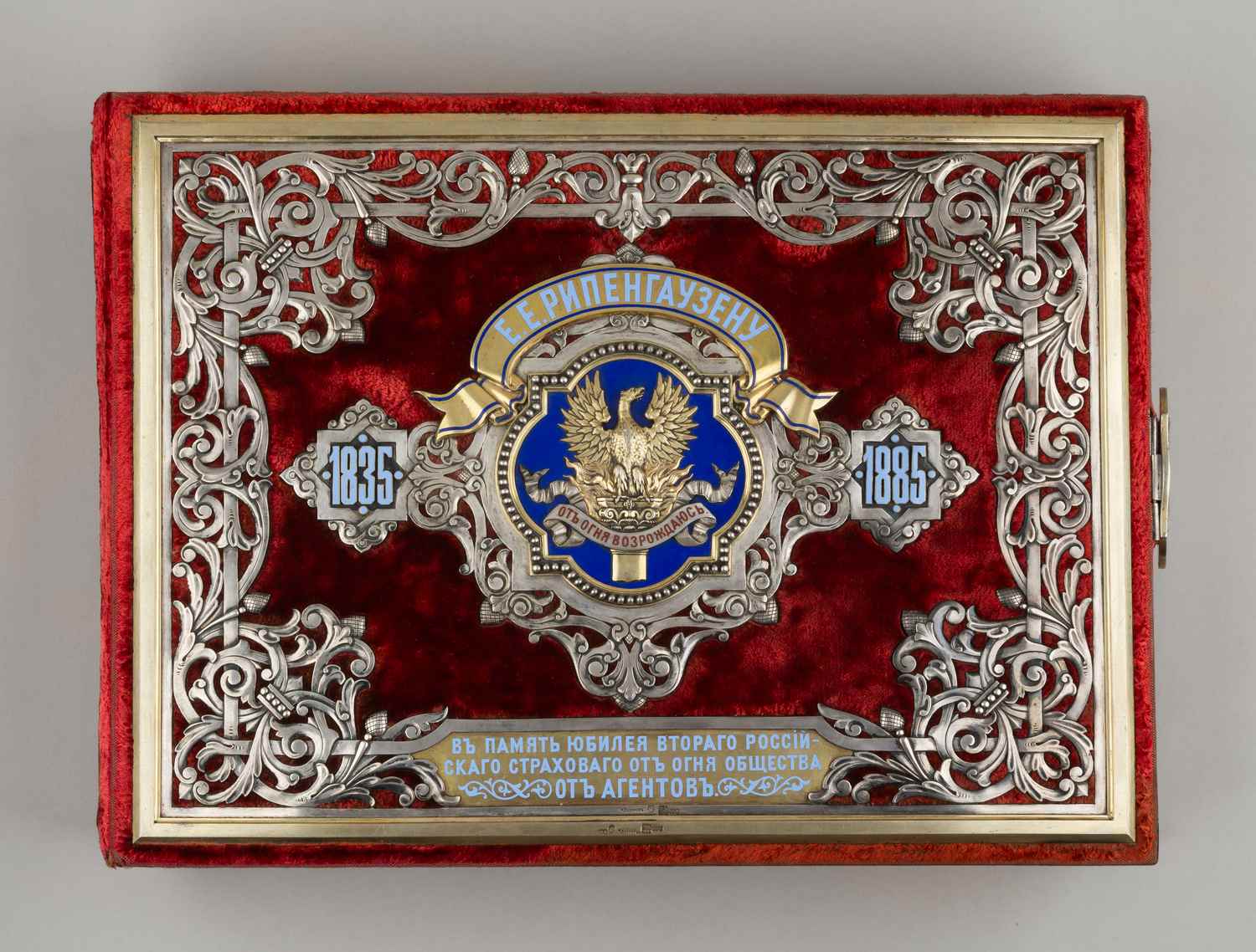 (Сазиков) Альбом для фото «В память 50 летнего юбилея второго российского Страхового от огня общества» с изображением птицы Феникс и девиза «От огня возрождаюсь».
Россия, Санкт-Петербург, фирма поставщика Двора П. Сазикова, 1885.
