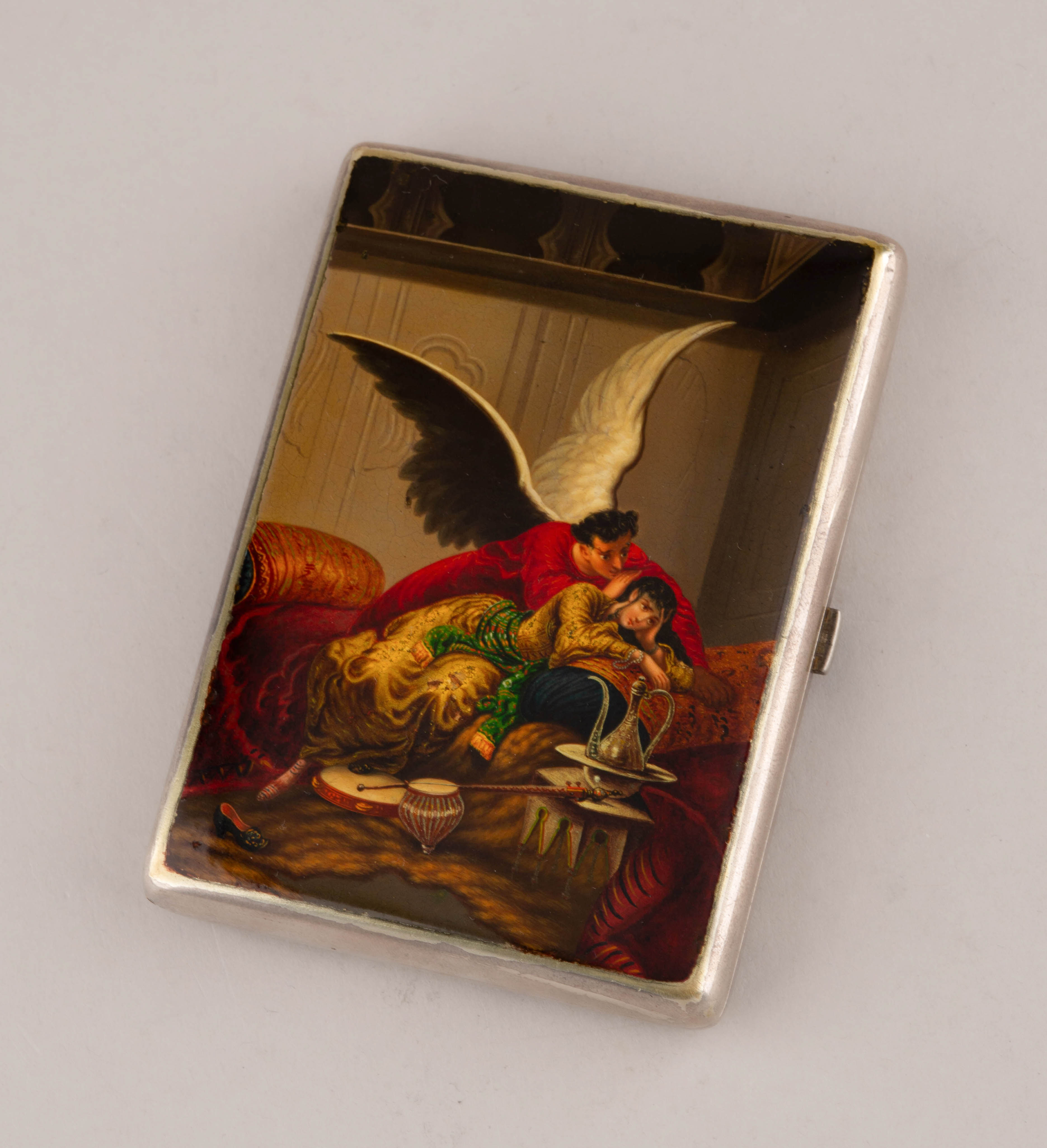 (Зичи М.А.) Портсигар «Демон» («Не плачь, дитя»). 
Россия, Москва, мастер – Зиновьев П.С.,  по иллюстрации Зичи М.А. к поэме Лермонтова М.Ю. «Демон», 1899-1901-е годы.