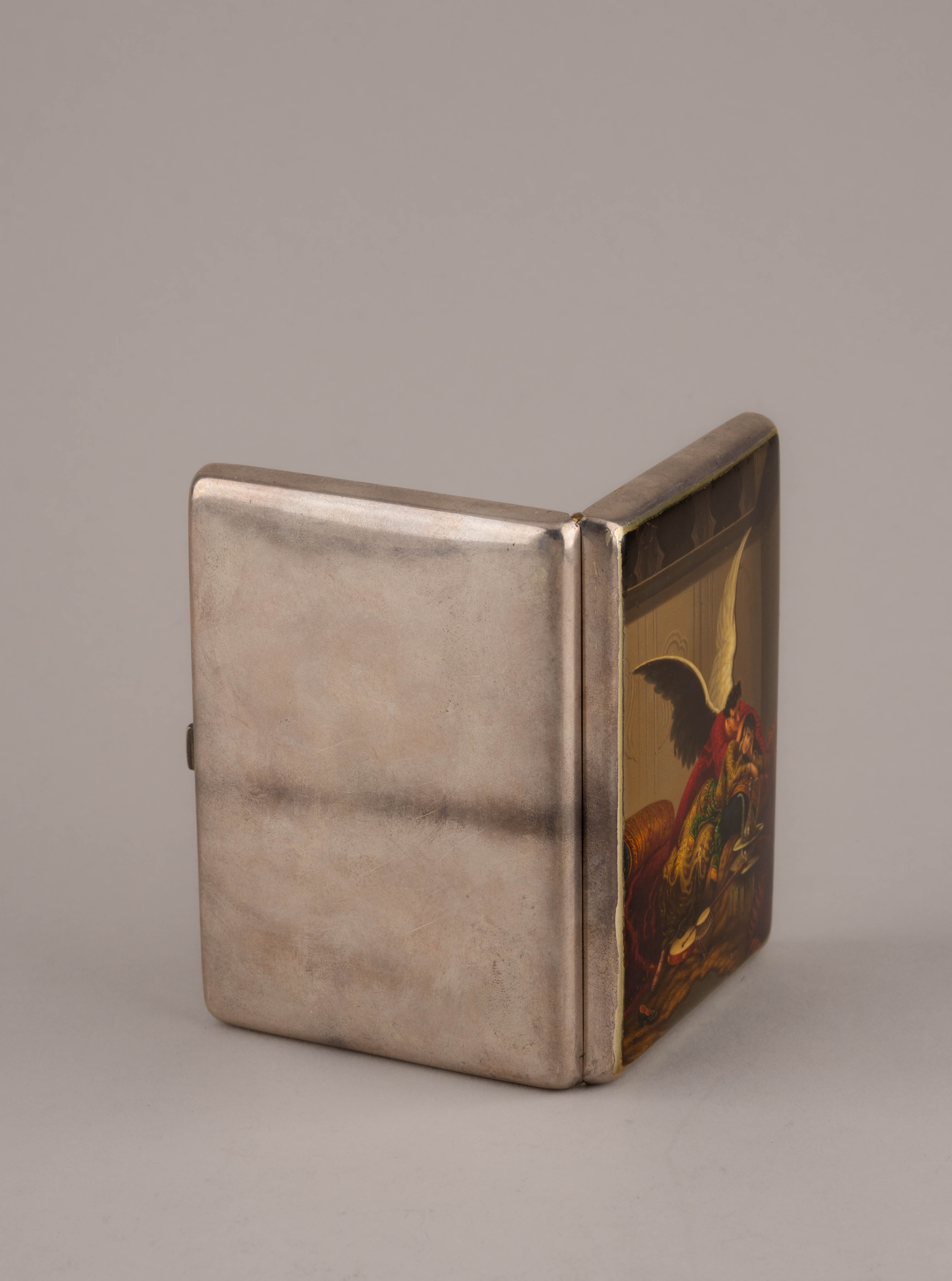 (Зичи М.А.) Портсигар «Демон» («Не плачь, дитя»). 
Россия, Москва, мастер – Зиновьев П.С.,  по иллюстрации Зичи М.А. к поэме Лермонтова М.Ю. «Демон», 1899-1901-е годы.