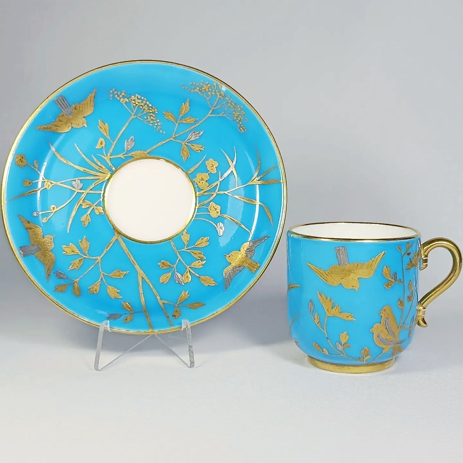 Чашка с блюдцем кофейная бирюзовая золотой и серебряной красками в виде птиц в растениях
Англия, Minton, 1870-е годы.